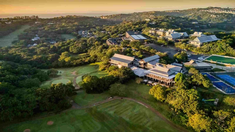 Aerial view of golf clubhouse with courts at sunset